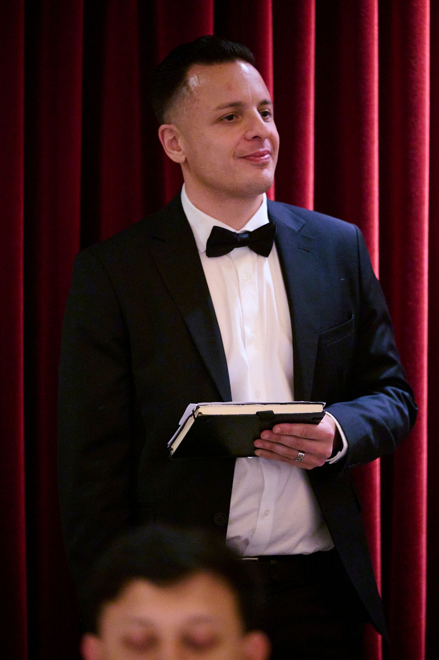Naïm Terrache with his notes, ready to go on, in front of a red stage curtain